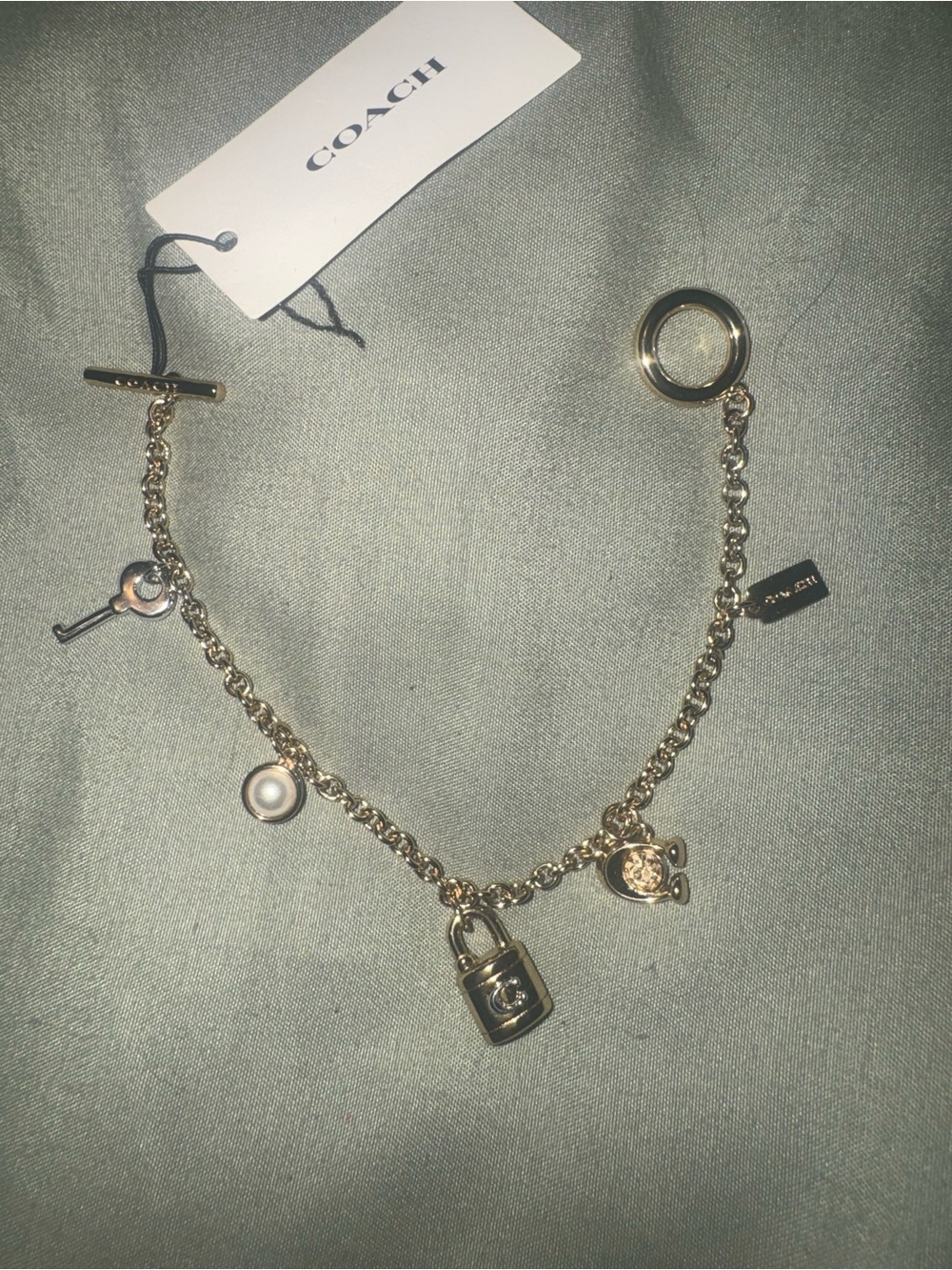 Coach Gold tone Charm Bracelet with Padlock, Key and Pearl Accents CD855 A31